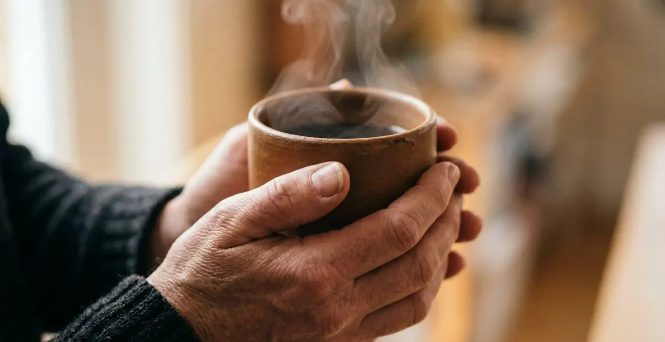 Macro close-up of hands holding warm beverage showing textural details of rest and recovery