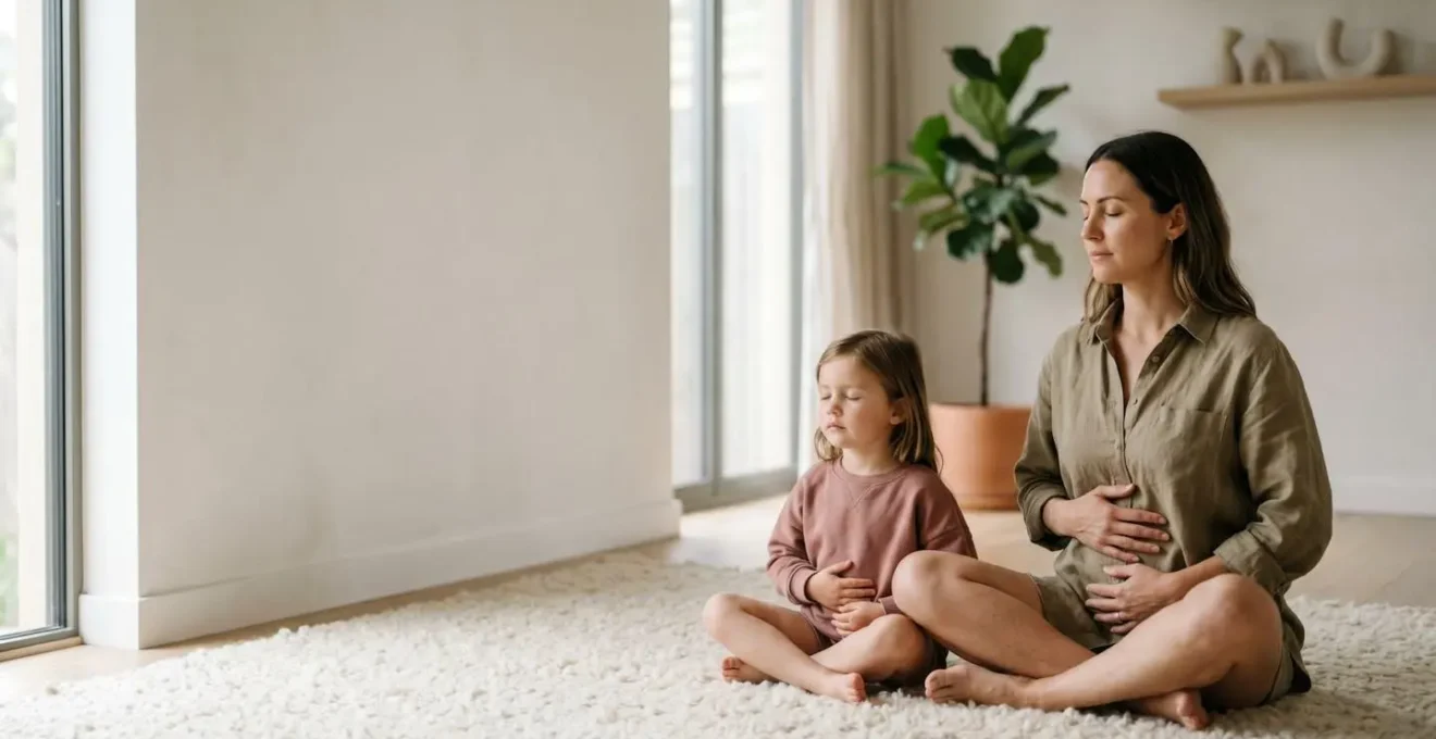 Wide environmental shot showing a parent and child sitting together in a peaceful corner of a bright room, both engaged in a quiet breathing exercise with hands placed on their own bellies, natural light streaming through window